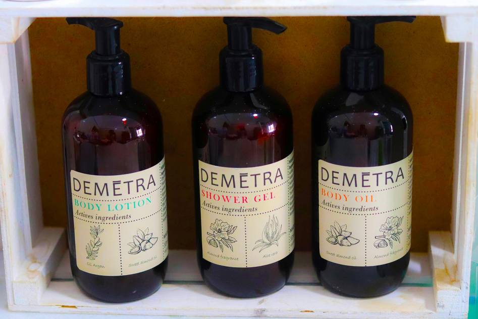 Assorted premium shower gel bottles with fresh botanicals on marble